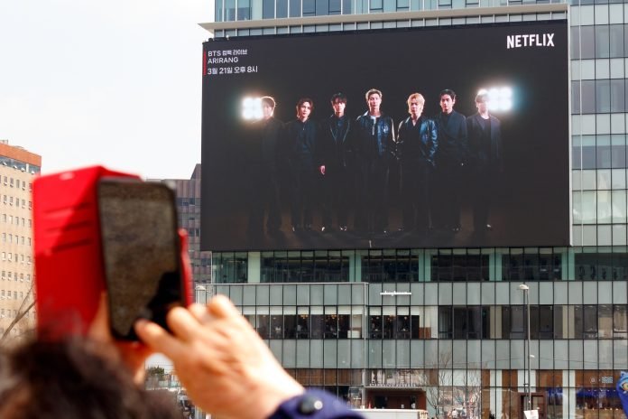 Seoul,,South,Korea,-,Mar,20,2026:,A,Person,Photographs BTS en un anuncio publicitario | Foto: Shutterstock